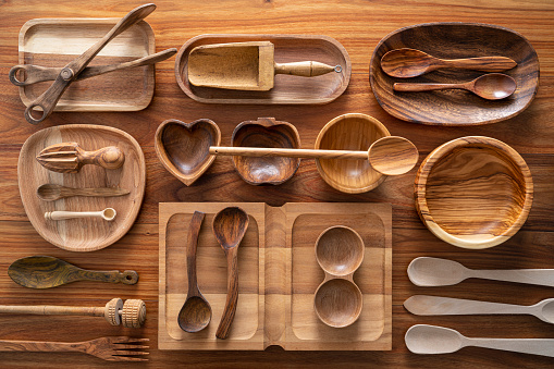 Wooden kitchen utensils cuttlery inventory on wood background as plates, bowls, wooden spoons