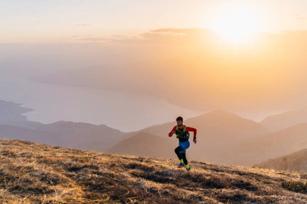 istock Young man trail runs up mountain at sunrise 1226075380