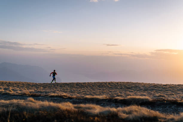 istock Young man trail runs up mountain at sunrise 1226076037