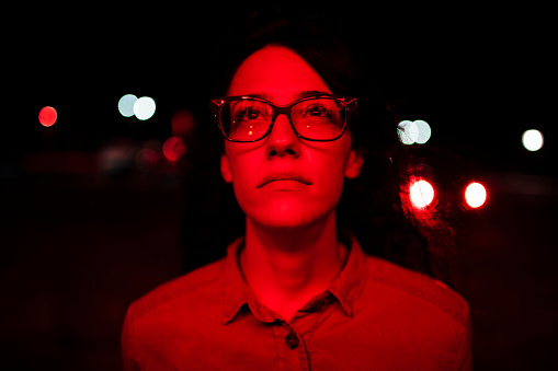 Portrait of a young woman covered in red light