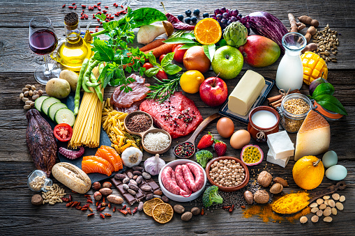 Food and drink large arrangement with carbohydrates protein vegetables and fruits legumes and dairy products on rustic board table
