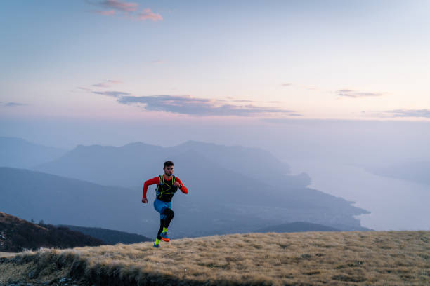 istock Young man trail runs up mountain at sunrise 1226076618