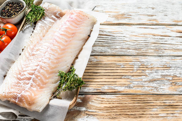 istock Fresh Raw Cod loin fillet with thyme.  White wooden background. Top view.  Copy space 1226076785