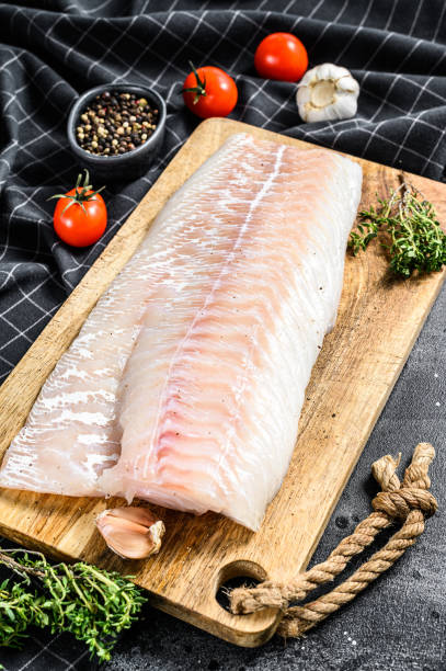 istock Fresh Raw Cod loin fillet with thyme.  Black background. Top view 1226076826