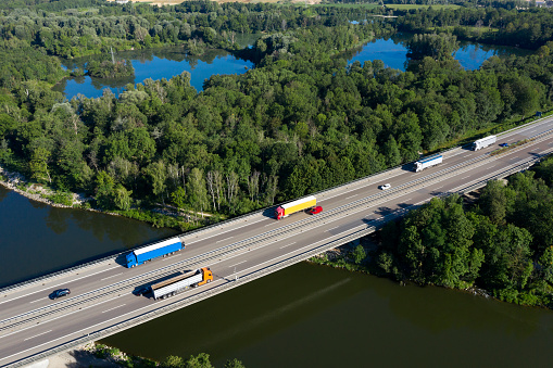 Heavy cargo on the highway bridge, a Danube River, aerial view.