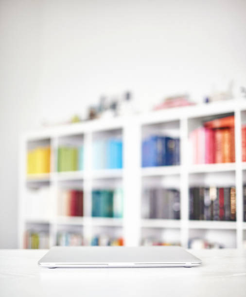 Modern home office with white desk and closed laptop