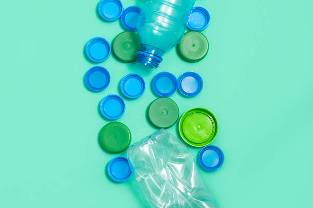 istock Composition of plastic bottles and plastic bottle caps on green background with space for text. Plastic free concept 1226084021