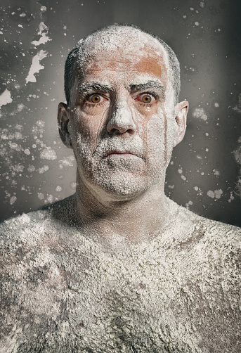Man with white dust on body staring at camera