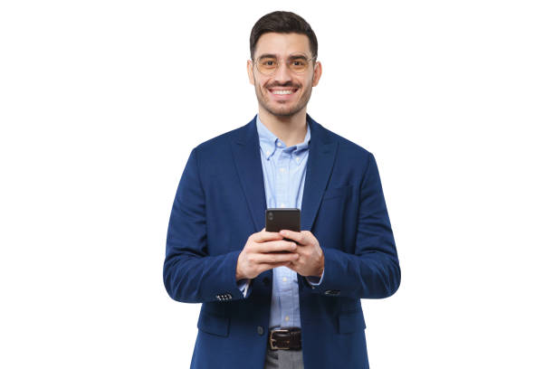 istock Young businessman in blue suit, holding smartphone in hands, exchanging messages with colleagues and friends, smiling happily, isolated on white background 1226086648
