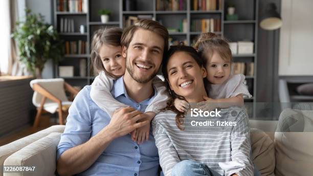 Portrait Of Young Family With Small Daughters At Home Stock Photo - Download Image Now
