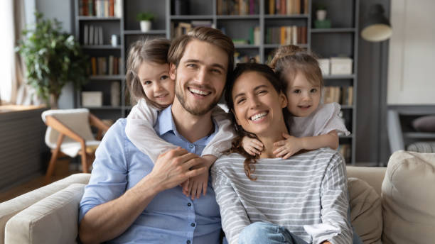 portrait of young family with small daughters at home - family portrait imagens e fotografias de stock