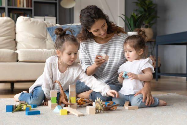 istock Young mom play with little daughters at home 1226087866
