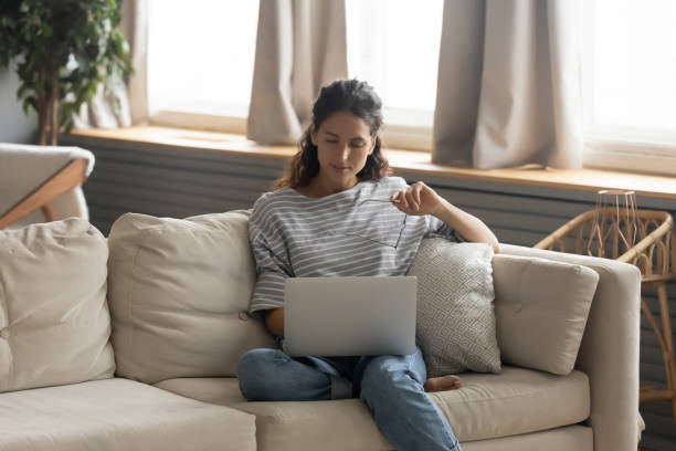 istock Young woman relax on couch using laptop 1226087894