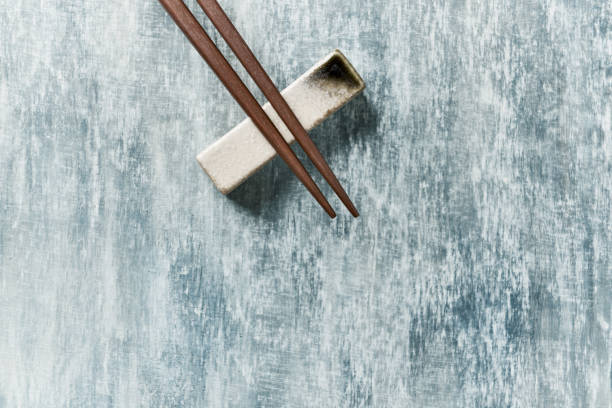 istock Wooden chopsticks and chopstick rest on rustic wooden background. Top view. Copy space. 1226089376