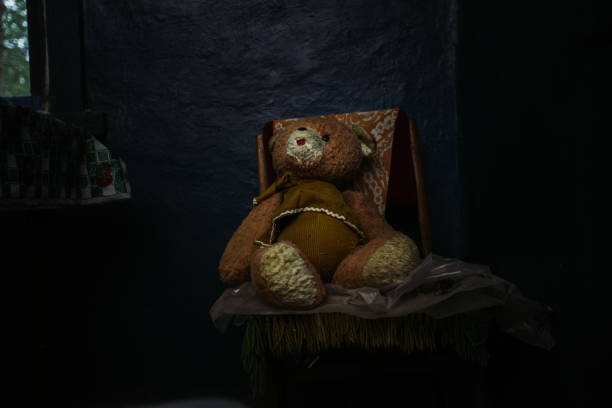 Old Teddy bear sitting in abandoned house Old Teddy bear sitting in abandoned house. behavior teddy bear doll old stock pictures, royalty-free photos & images