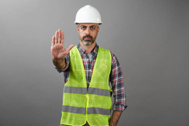 Worker man with medical mask showing stop gesture Worker man with medical mask showing stop gesture. Handyman worker wearing face mask and protective hard hat helmet hardhat protective glove safety stock pictures, royalty-free photos & images
