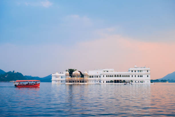 Lake Palace palace on Lake Pichola in twilight, Udaipur, Rajasthan, India Romantic luxury India travel tourism - tourist boat in front of Lake Palace (Jag Niwas) complex on Lake Pichola on sunset with dramatic sky, Udaipur, Rajasthan, India udaipur stock pictures, royalty-free photos & images