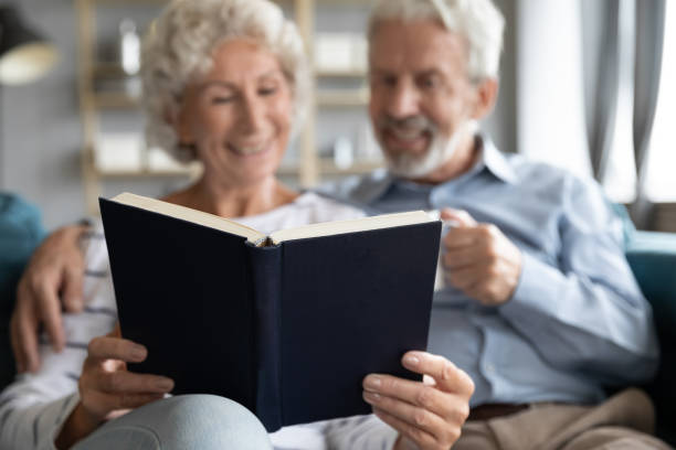 istock Happy middle aged married couple reading novel together. 1226093610
