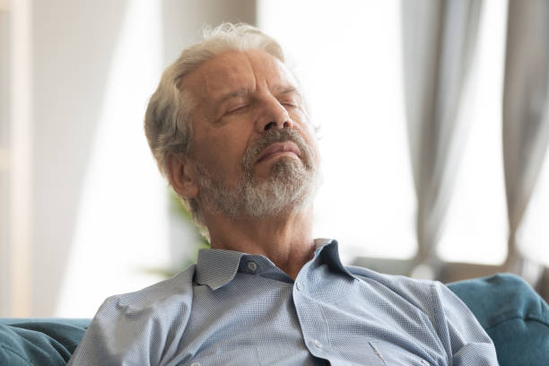Peaceful serene middle aged mature man relaxing on comfortable couch. Head shot close up peaceful serene hoary middle aged mature man relaxing on comfortable couch with closed eyes. Happy senior old retired grandfather sleeping, enjoying stress free time on sofa. sleeping grandpa stock pictures, royalty-free photos & images