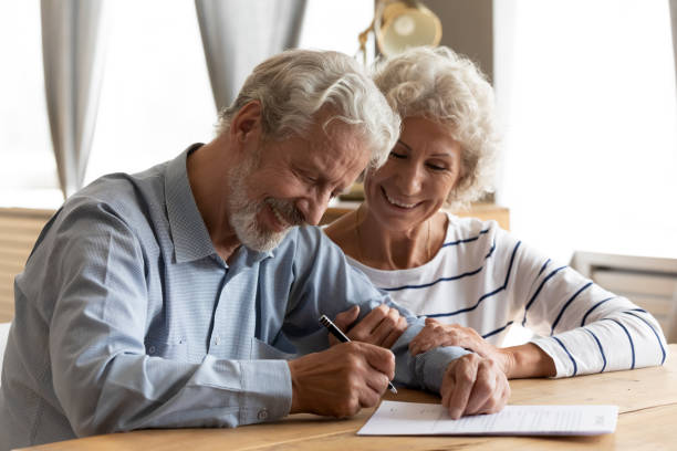 istock Happy middle aged retired couple signing marriage contract. 1226093729