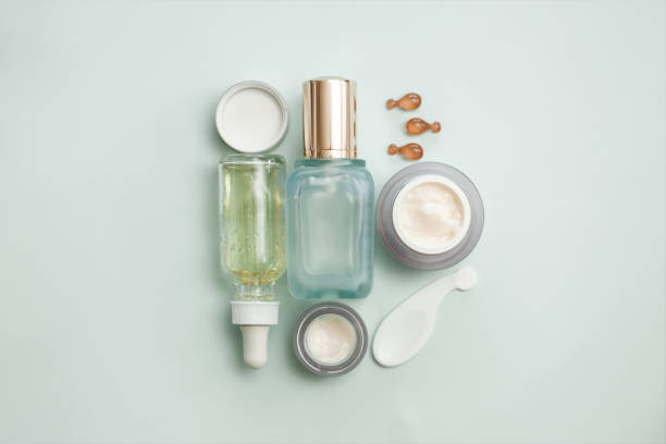 istock Face serum bottle with face creams, face oil capsules on light teal background. cosmetics flat lay. 1226094751
