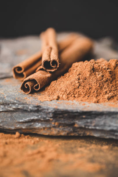 istock Cinnamon stick and powder on black background with stones 1226098726