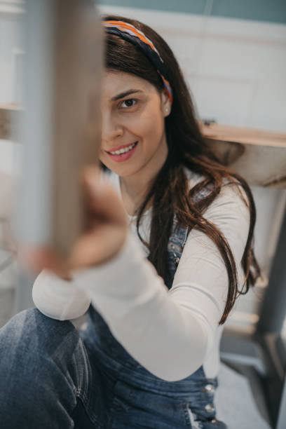 istock Woman in overalls assembling flat pack furniture 1226098846