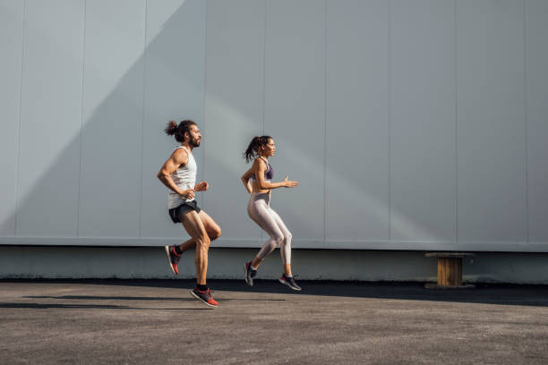 istock Urban Runners: Fit Man and Woman Running Outdoors Together 1226100873