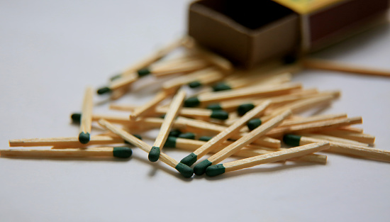 Up close picture of scattered match sticks and matchbox in background
