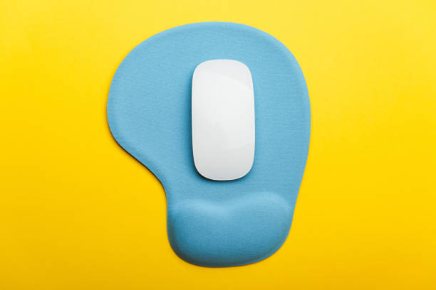 Computer mouse pad and mouse on a yellow background