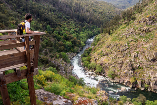 Tourist watching the landscape of the Paiva river from the Paiva Walkways, near Arouca in Portugal. stock photo