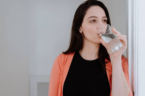 istock Woman taking medicine with water in the kitchen 1226105596