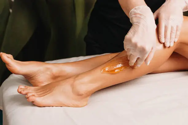 Photo of Close up photo of a sugaring procedure done at the salon during a leg skin protection session