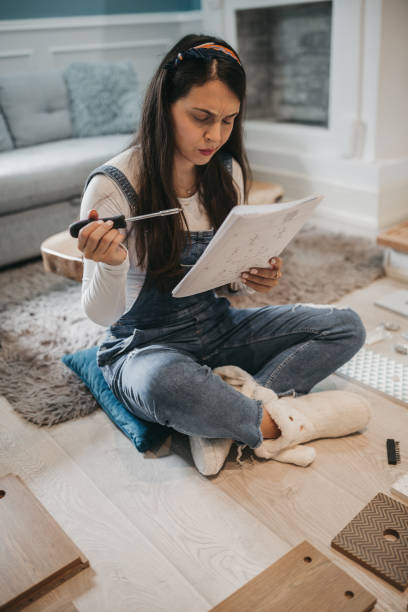 istock DIY. Young Woman Assembling flat pack furniture with a screwdriver 1226105899