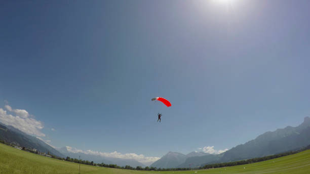 istock Paraglider comes into landing on grassy field 1226106513
