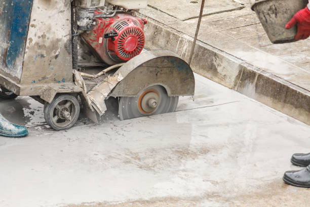 trabajador usando máquina de hoja de sierra de diamante cortando carretera de hormigón en el sitio de construcción - serrar fotografías e imágenes de stock