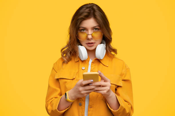 istock Young woman using smartphone and looking at camera 1226111118