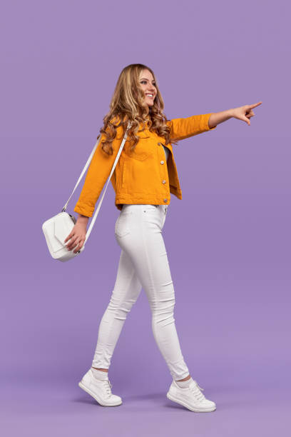 istock Stylish woman walking and pointing aside 1226111154