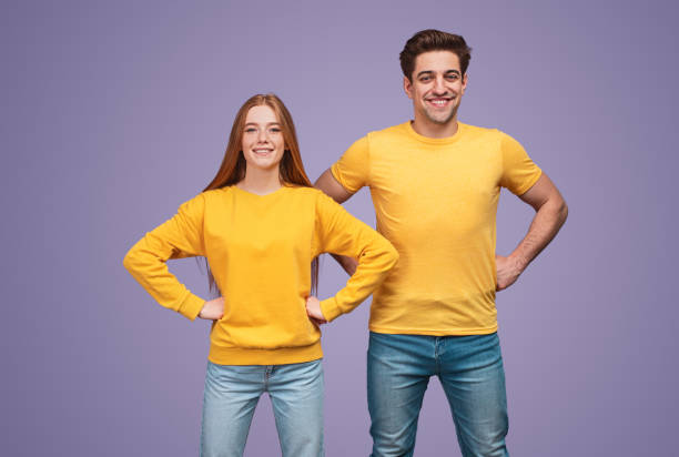 istock Positive active young couple in yellow shirts looking at camera 1226111175