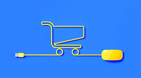 Yellow mouse cable forming shopping cart icon on blue background. Horizontal composition with copy space. Online shopping concept.