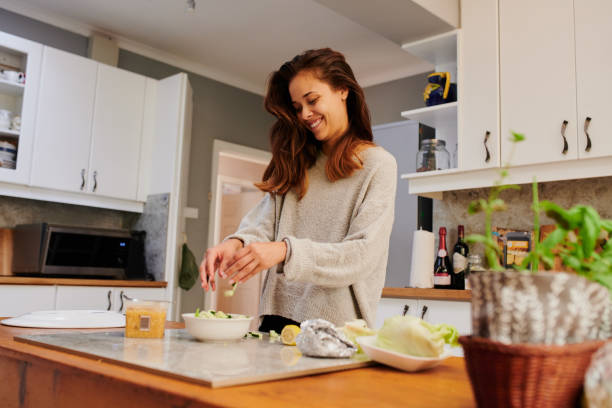 Eat better, feel better Shot of a young woman preparing a healthy meal at home ketogenic diet photos stock pictures, royalty-free photos & images