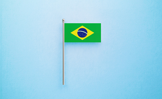 Tiny Brazilian flag on light blue background. Horizontal composition with copy space. Directly above.