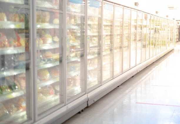 Big glass door deep freezer refrigerater at supermarket. Suitable for presenting new ice cream, cakes and frozen product in between many others. stock photo