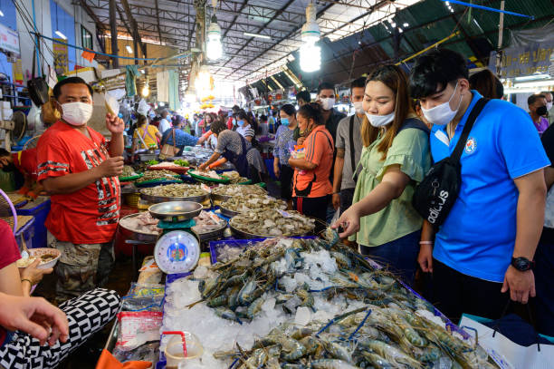 pessoas ware máscara facial escolhendo camarão cru no mercado pak nam - head ware - fotografias e filmes do acervo