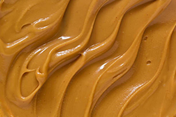 Peanut butter texture background Peanut butter texture background. Brown nut paste smear close up. Delicious natural food creamy smooth spread macro top view whipped food photos stock pictures, royalty-free photos & images