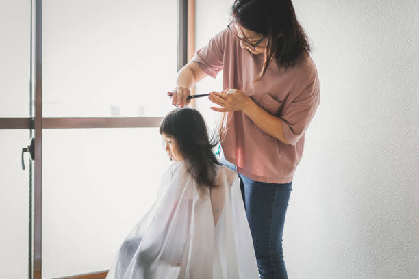 istock Mother cutting her daughter's hair at home 1226132942