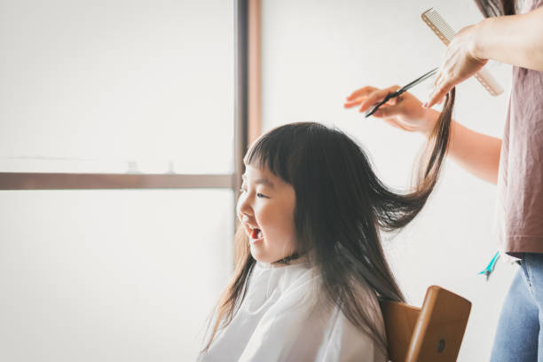 istock Mother cutting her daughter's hair at home 1226132972