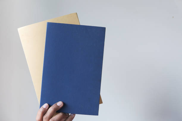istock hand holding books against a wall 1226134621