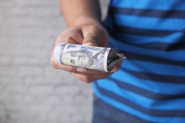 istock man hand with us 100 dollar cash with copy space 1226134691