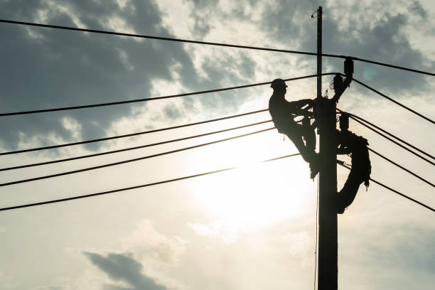 elektriker-arbeiter klettern strommast, um die beschädigten stromkabelleitung probleme nach dem sturm zu reparieren. stromleitungsunterstützung, technologiewartung und entwicklungsindustriekonzept - stange stock-fotos und bilder